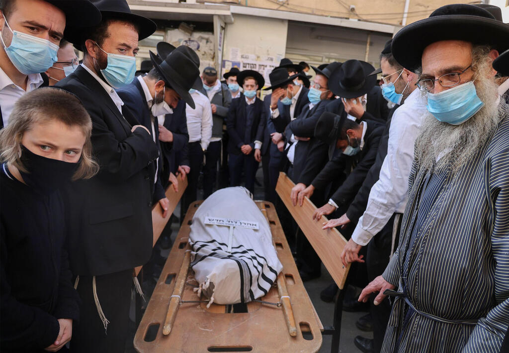 Ultra-orthodox Jewish men mourn during the funeral of Rabbi Aharon David Hadash 