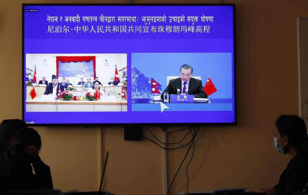 Nepalese government officers watch a live telecast of a joint announcement on the height of Mount Everest, in Kathmandu, Nepal 
