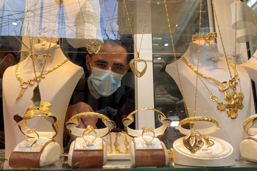 Palestinian Christian jeweller Melad Al-Amash arranges gold jewellery at his shop in Gaza City 