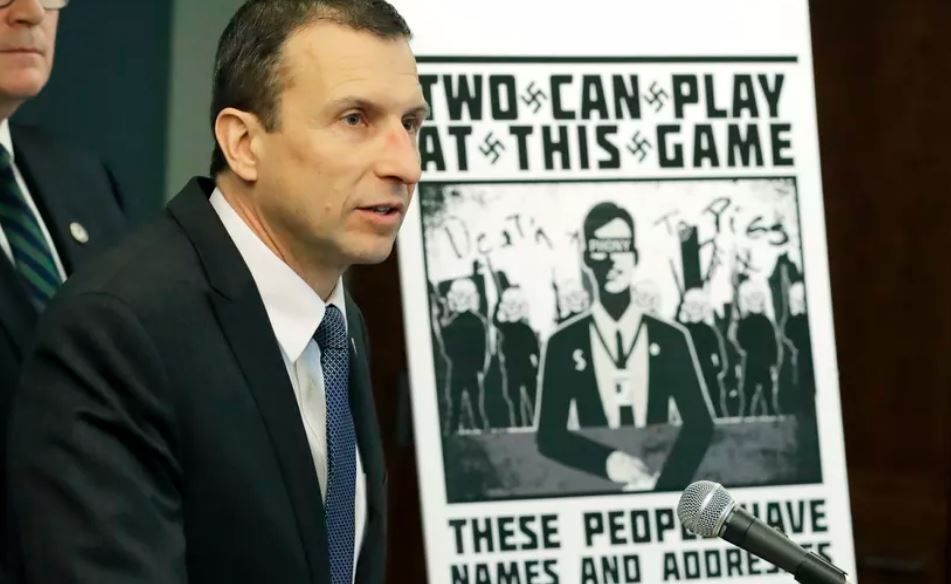 Raymond Duda, FBI Special Agent in Charge in Seattle, speaks as he stands next to a poster that was mailed earlier in the year to the home of Chris Ingalls