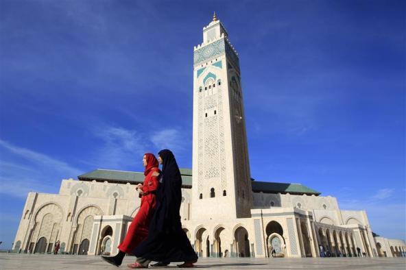 Muslim women walk by a mosque in Rabat, Morocco 