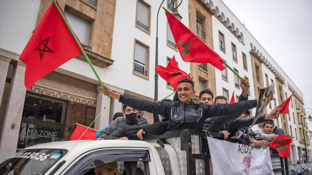  Moroccans celebrate in front of the parliament building in Rabat after the US adopted a new official map of Morocco that includes the disputed territory of Western Sahara