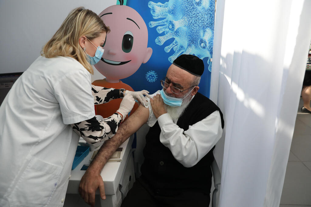 An elderly man is vaccinated against coronavirus in Tel Aviv (Photo: EPA) מבצע חיסוני הקורונה בישראל