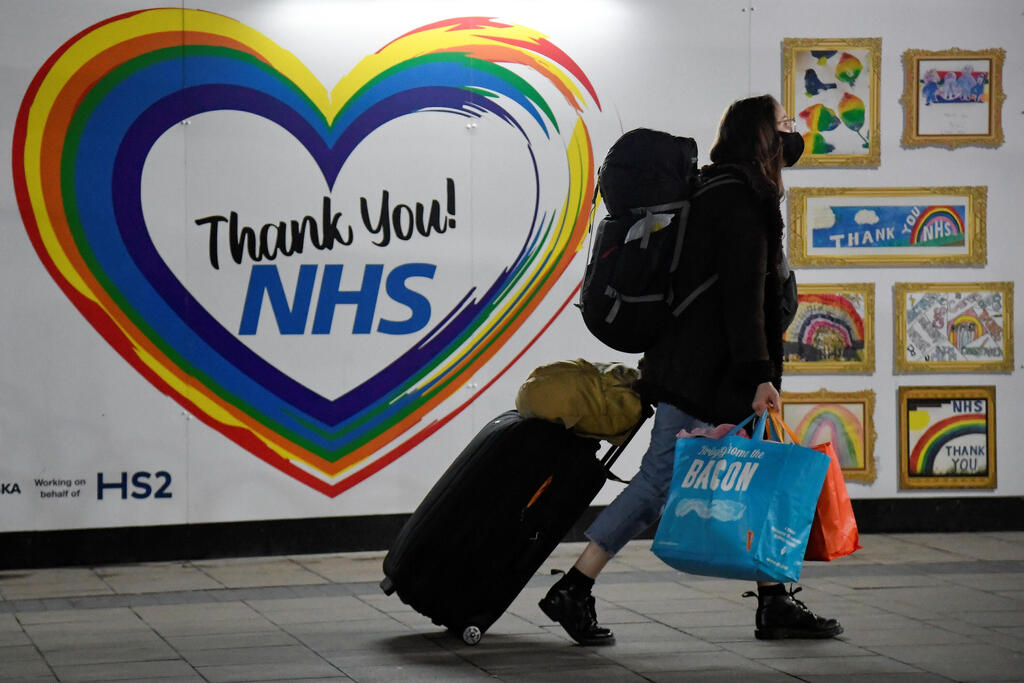 A traveller walks past a message of thanks to health workers outside Euston railway station in London, Dec. 20, 2020