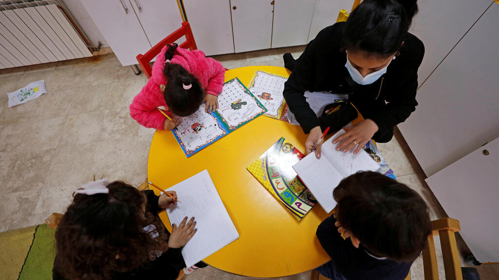 A staff member teaches children at The Creche, a house sheltering children, in Bethlehem