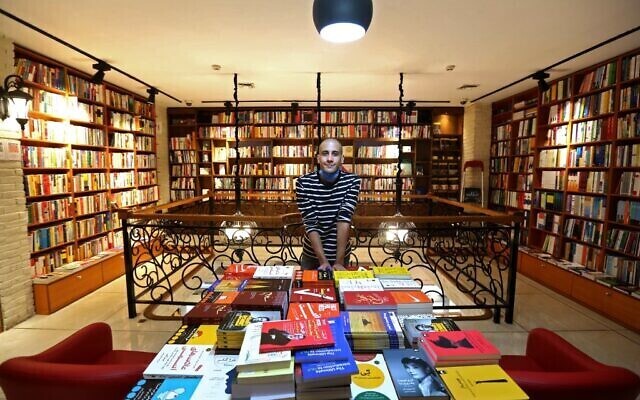 An Iranian employee poses for a picture at a bookstore in Tehran’s Enqelab (Revolution) street 