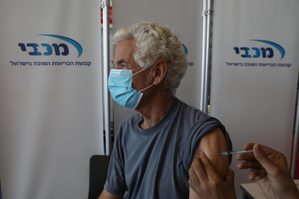 A man receives the coronavirus vaccine at a Maccabi clinic in Tel Aviv (Photo: AFP) חיסון קורונה בישראל תל אביב