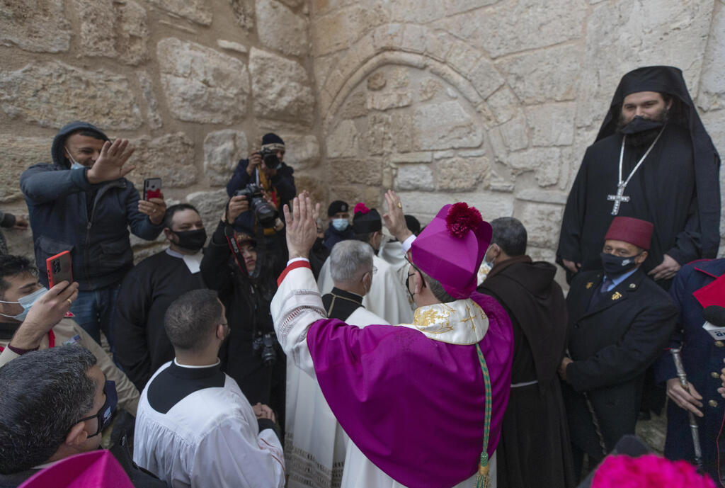 Archbishop Pierbattista Pizzaballa, the top Roman Catholic cleric in the Holy Land, waves as he arrives for the midnight Mass at the Church of the Nativity