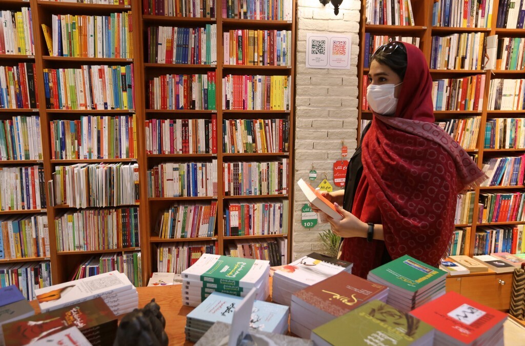 A woman picks a book at a bookstore on Enqelab (Revolution) street in Iran's capital Tehran 