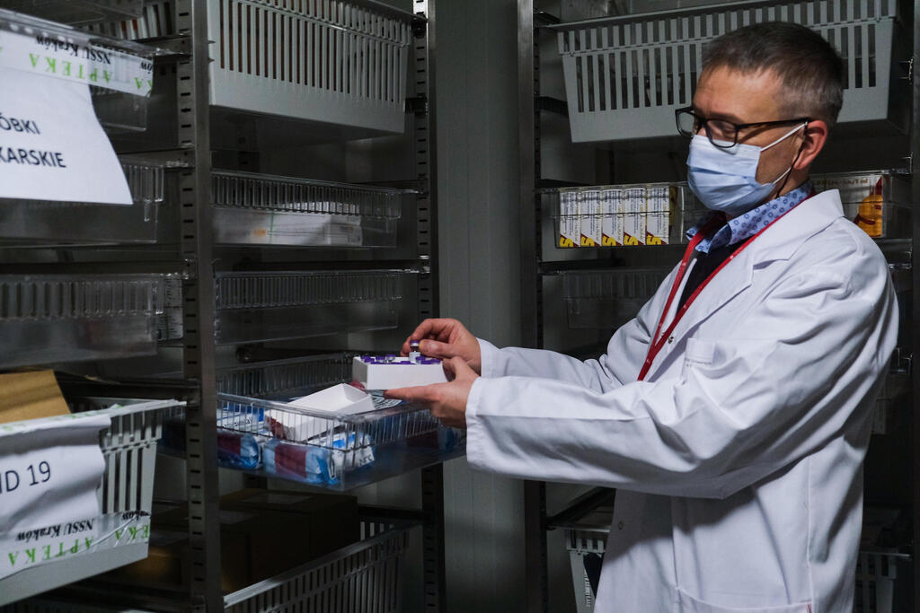 A doctor picks doses of Pfizer BioNTech Covid-19 vaccine inside a cold storage room at Krakow University Hospital on December 27, 2020 in Krakow, Poland 