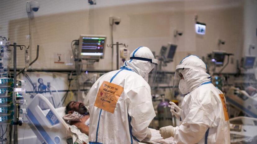 Two healthcare professionals treat a patient in the coronavirus unit of the Ziv medical center in Safed, Israel 