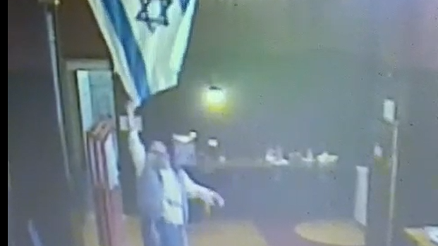 המתפלל מוריד את הדגל בבית הכנסת