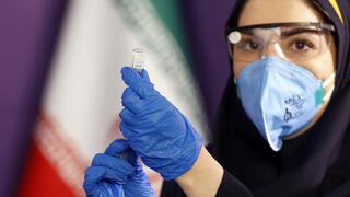 קורונה איראן עובדת בריאות מציגה מנה של חיסון שפיתחה איראן לקורונה עכשיו מתחילים לנסות על בני אדם