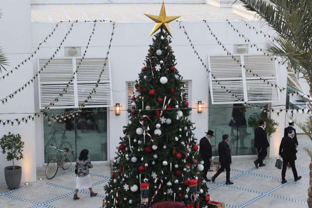 A rabbi and other guests pass a Christmas tree to take part in an Israeli wedding ceremoney in Dubai, United Arab Emirates 