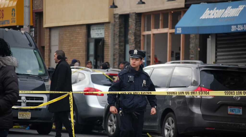 שוטר בפתח חנות המכולת הכשרה בג׳רזי סיטי, ניו ג׳רזי, זמן קצר אחרי מתקפת הירי