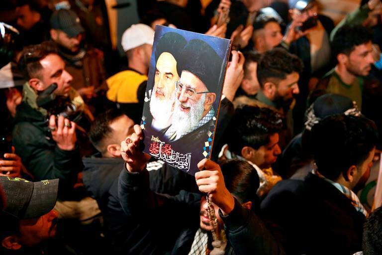 Members of the Popular Mobilization Forces (PMF) and their supporters chant slogans against the United States at Baghdad's international airport on Saturday, Jan. 2, 2021, for the anniversary of the killing of Abu Mahdi al-Muhandis, deputy commander of the PMF, and Gen. Qassem Soleimani, head of Iran's Quds Force in a U.S. airstrike 
