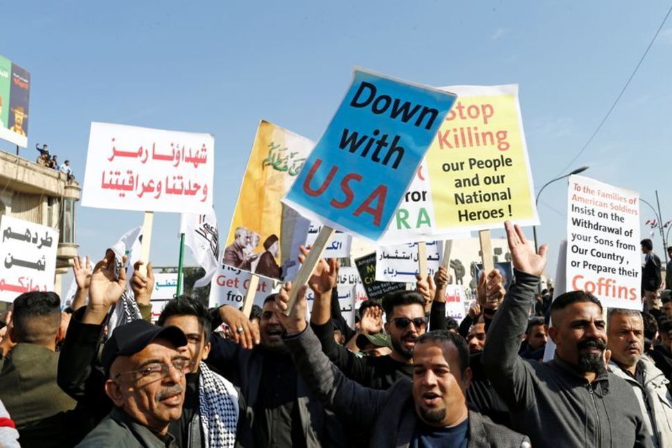 Iraqis, including supporters of Hashid Shaabi (Popular Mobilization Forces), hold placards as they gather to mark the one year anniversary of the killing of senior Iranian military commander General Qassem Soleimani and Iraqi militia commander Abu Mahdi al-Muhandis in a U.S. attack, in Baghdad, Iraq 
