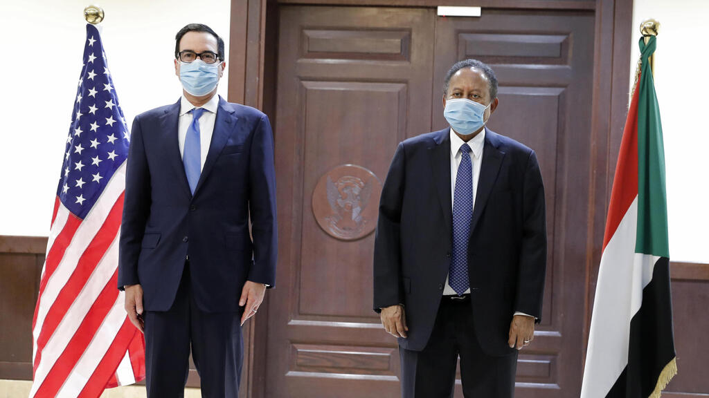 Sudanese Prime Minister Abdullah Hamdok, right, welcomes U.S. Treasury Secretary Steven Mnuchin to the Cabinet Building in Khartoum, Jan. 6, 2021 