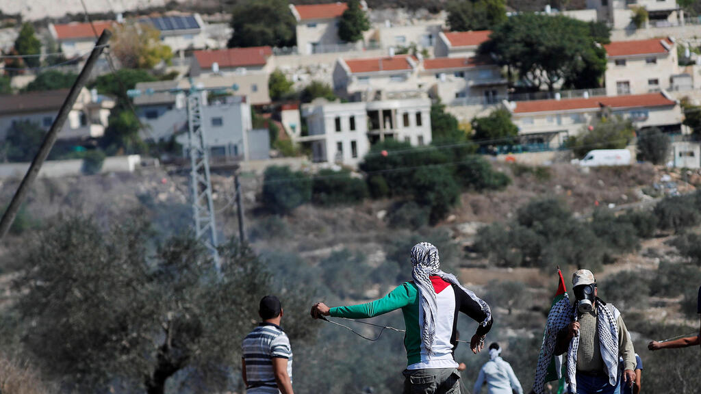 Palestinian demonstrators stand in front of a Jewish settlement during a protest, in Kafr Qaddum in the West Bank 