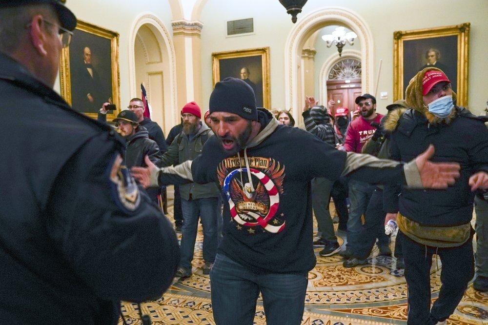 Trump supporters gesture to U.S. Capitol Police in the hallway outside of the Senate chamber at the Capitol 
