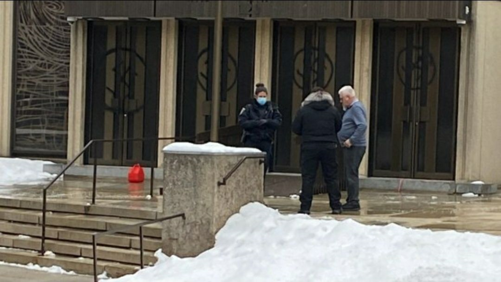 Police arrest the suspect in front of the Shaar Hashomayim synagogue