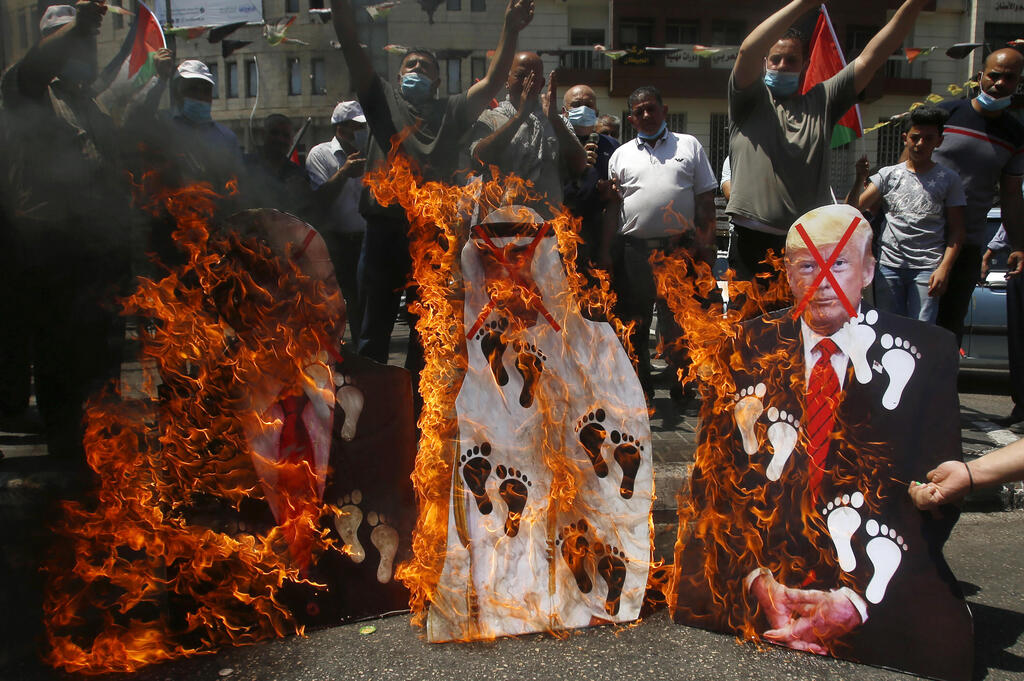 Palestinians burn pictures of U.S. President Donald Trump, Abu Dhabi Crown Prince Mohammed bin Zayed al-Nahyan and and Prime Minister Benjamin Netanyahu during an August 2020 West Bank protest against the United Arab Emirates' deal with Israel 