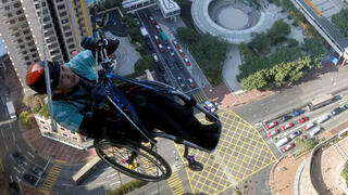 לאיי צ'י-ואיי מטפס פראלימפי מטפס על חבל במעלה מגדל גורד שחקים ב הונג קונג עם כיסא גלגלים