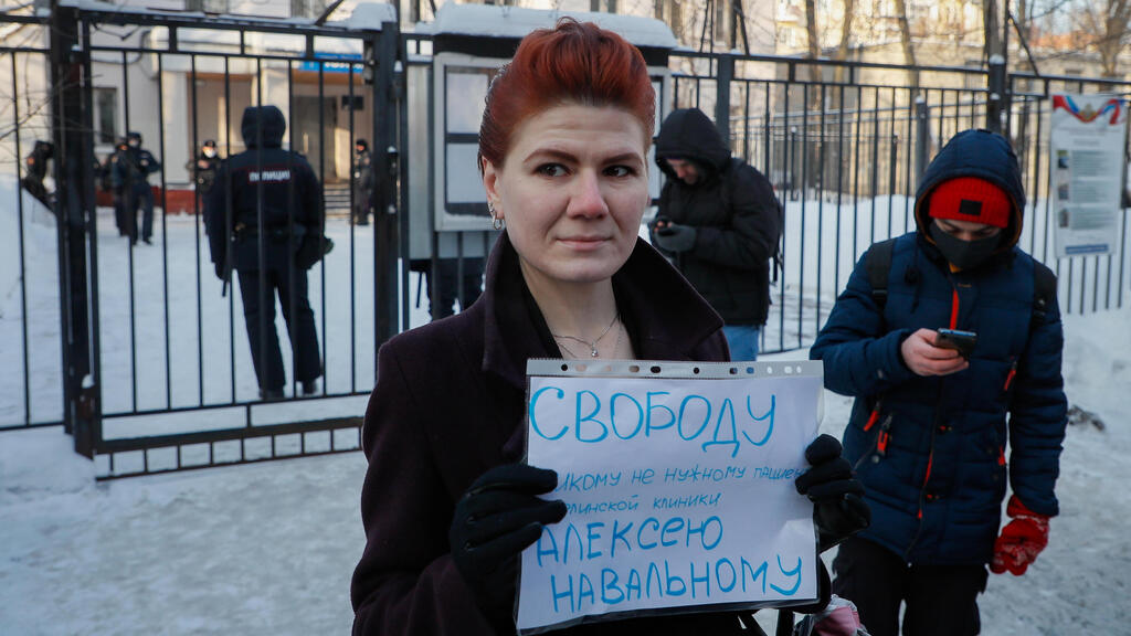 A woman holds a poster 'Freedom for Alexei Navalny' outside the police station where detained Russian opposition leader and anti-corruption activist Alexei Navalny is held