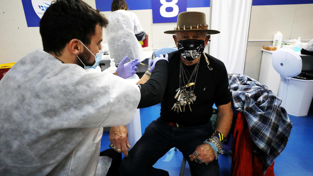 A man receives a vaccination against the coronavirus disease (COVID-19) at a temporary healthcare maintenance organisation (HMO) 