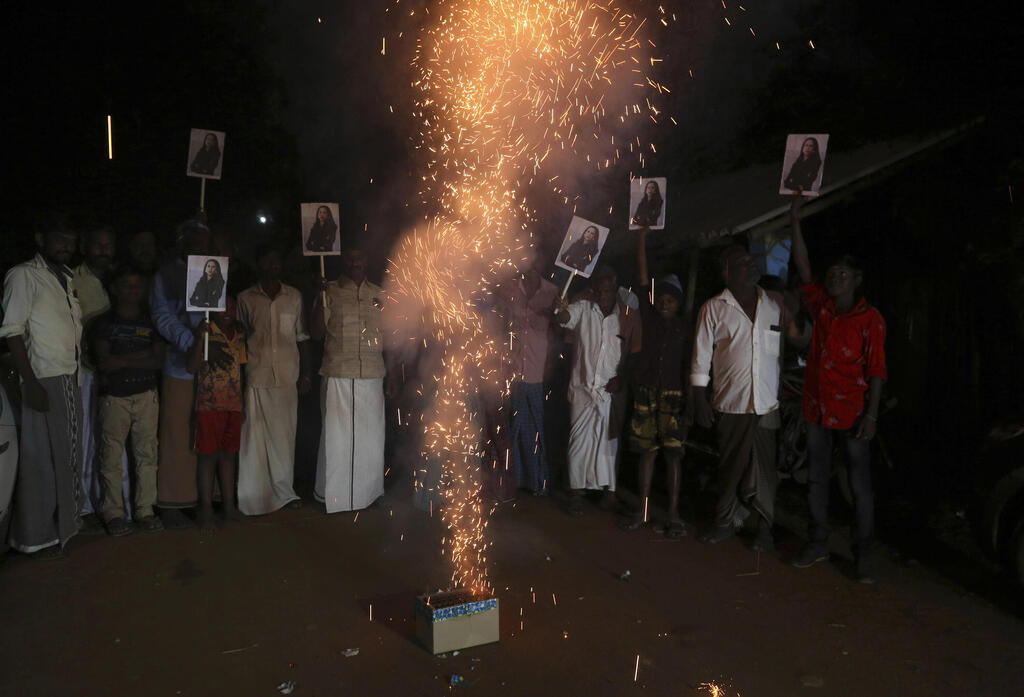 Villagers in Thulasendrapuram burst firecrackers and hold placards featuring U.S. Vice President Kamala Harris after her inauguration, Jan. 20, 2021 