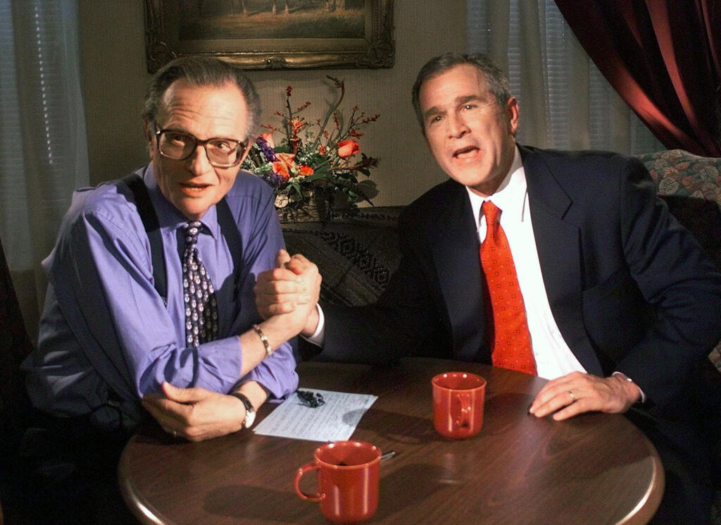 Larry King jokes with Republican presidential candidate George W. Bush after finishing the 'Larry King Live' show, Dec. 1999 