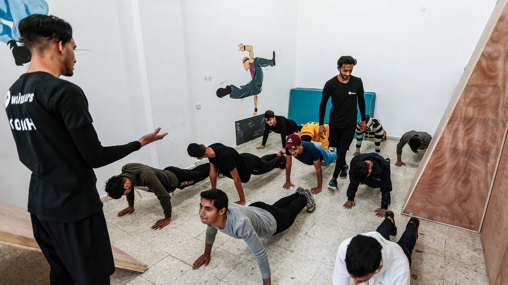 A coach trains Palestinian children at the Wallrunners Parkour Academy's training facility in Gaza