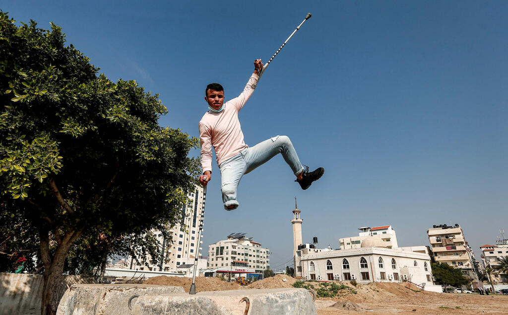 Mohamed Aliwa, a Palestinian youth whose leg was amputated near the knee in 2018 after he was hit by Israeli army fire during protests along the fortified border separating the Gaza Strip from Israel, shows off his parkour skills