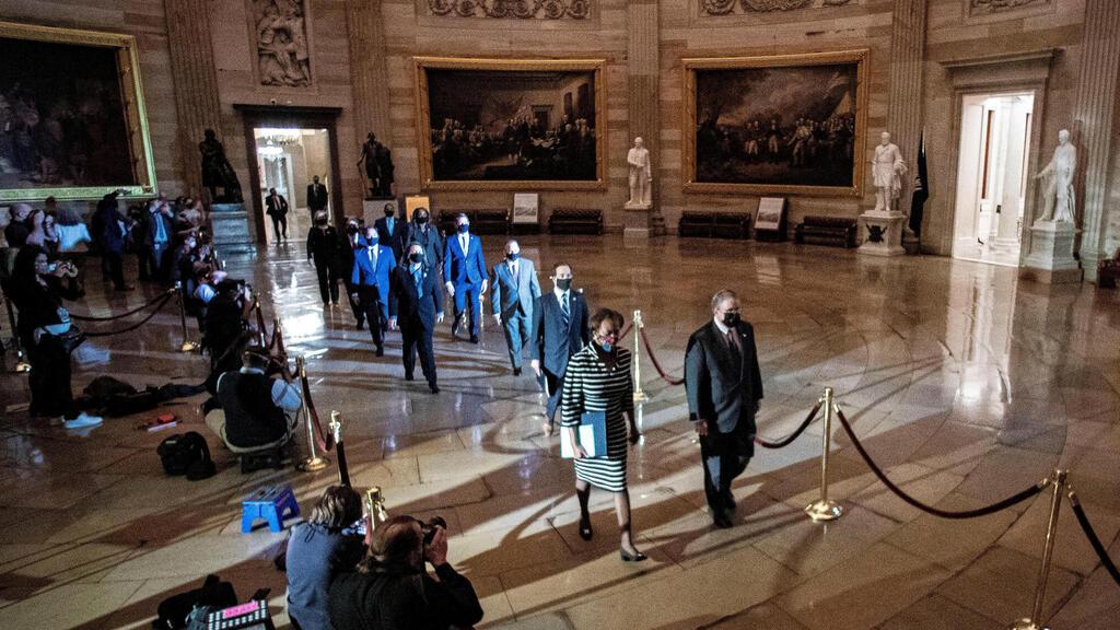 House impeachment managers walk the article of impeachment against former U.S. President Donald Trump through the Rotunda of the U.S. Capitol  