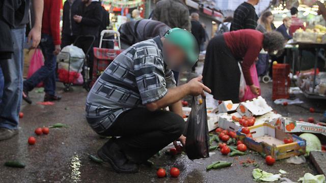 People collecting food from ground in Carmel Market in Tel Aviv before the pandemic 