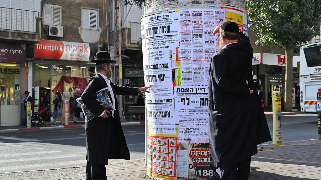 Ultra-Orthodox men in Bnei Brak looking at news bulletins 