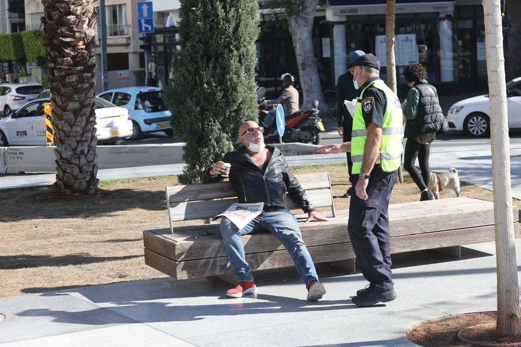 A police officer in Tel Aviv enforces public health regulations (Photo; Moti Kimchi) שוטרים אוכפים את הסגר השלישי בכיכר דיזנגוף