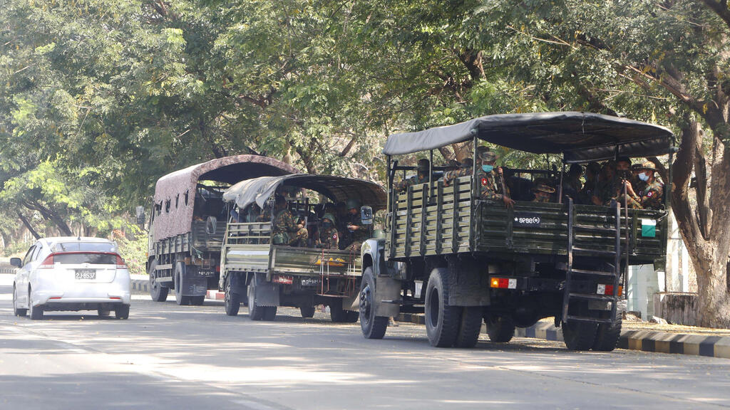 Soldiers sit inside trucks parked on a road in Naypyitaw, Myanmar