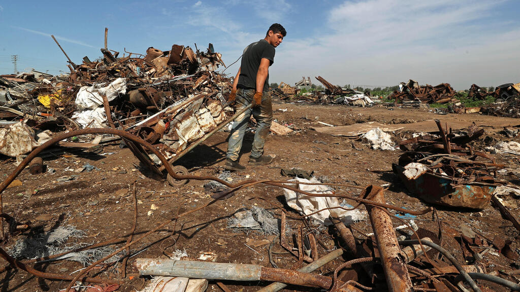 A Palestinian worker sorts scrap metals in preparation for exports, at a scrap yard east of Gaza 