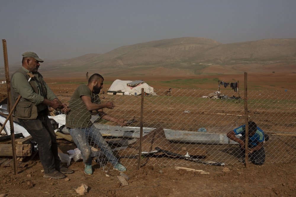 Palestinian Bedouins boy rebuild a fence for an animal pen after Israeli troops demolished tents and other structures of the Khirbet Humsu hamlet in the Jordan Valley in the West Bank 