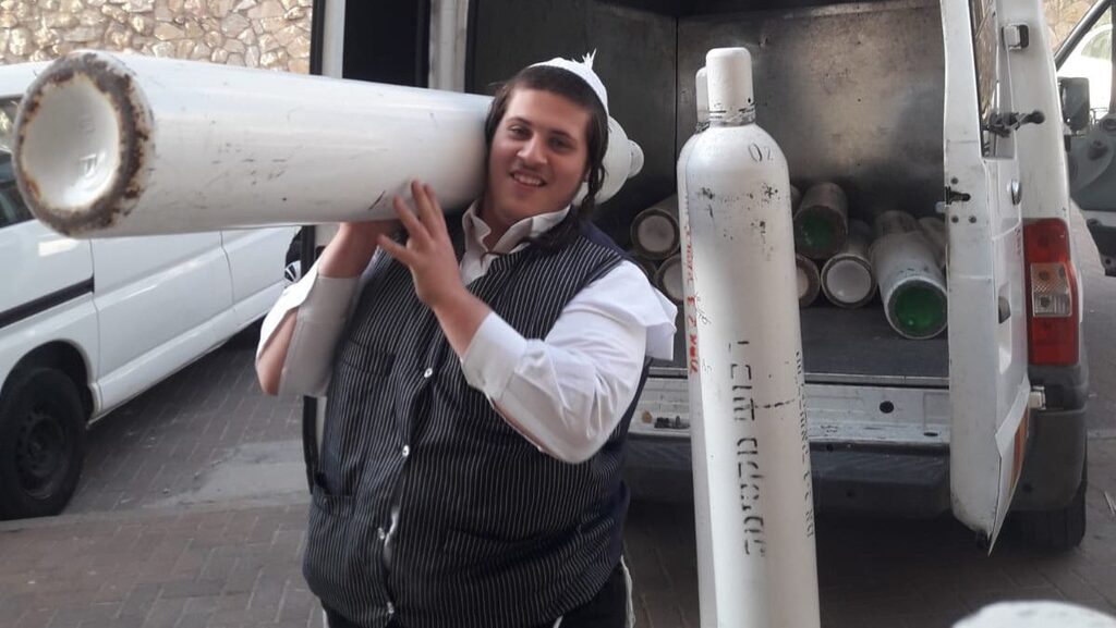 A Chasdei Amram volunteer delivers an oxygen tank to a home-bound COVID-19 patient in Jerusalem 