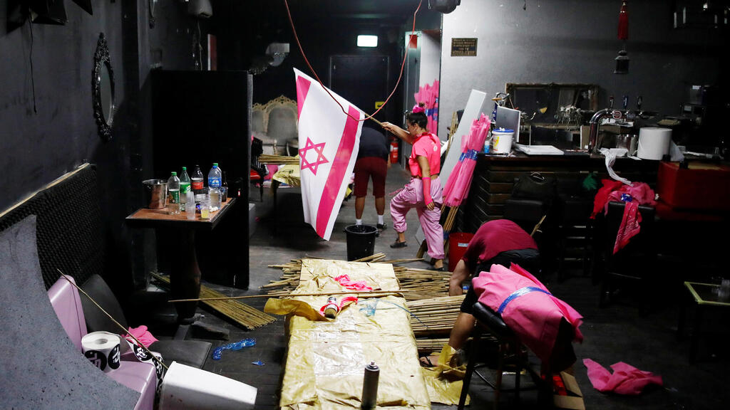 Members of the 'Pink Front' prepare flags in Tel Aviv ahead of the weekly anti-Netanyahu demonstrations in Jerusalem, Oct. 2020 