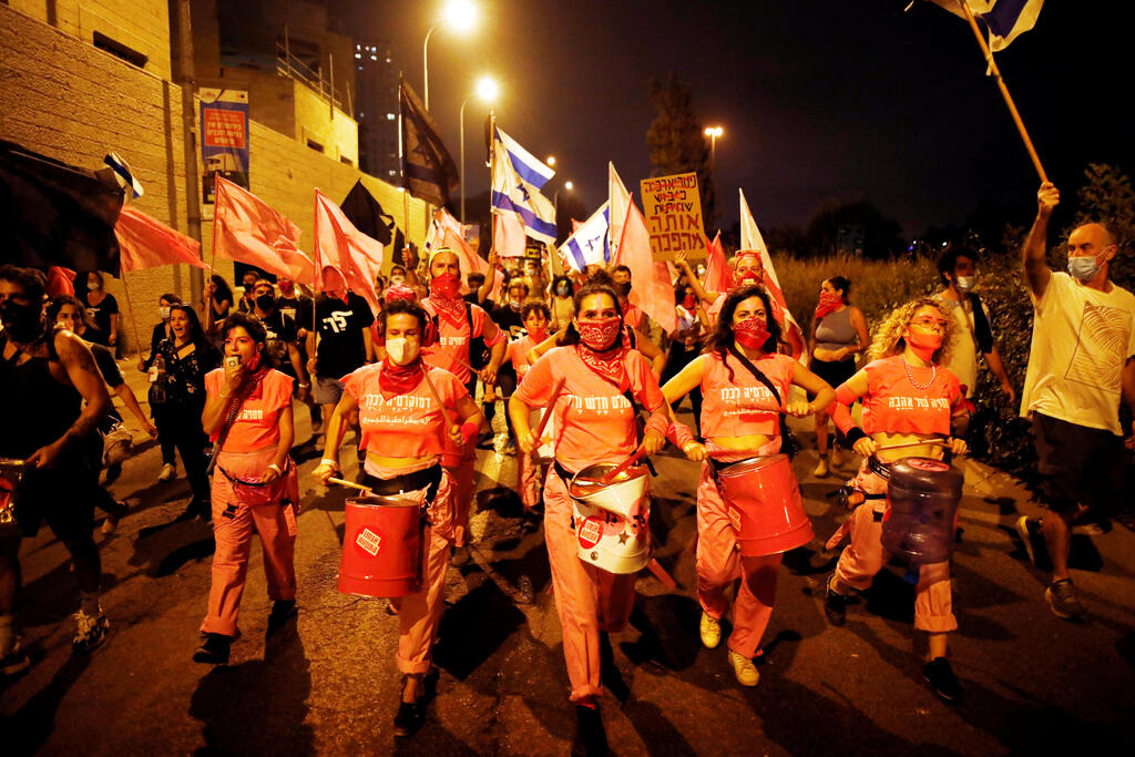 Karin Brauner, Sharon Saguy and Yarden Grosser members of the 'Pink Front' protesters play drums as they march during a weekly anti-Netanyahu demonstration in Jerusalem 
