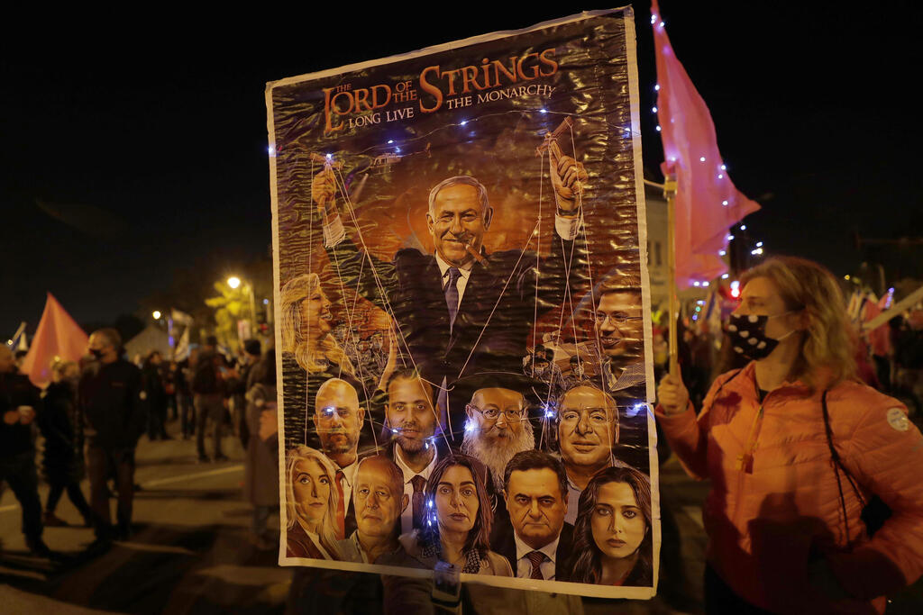 Israeli protesters hold anti-Netanyahu posters during a protest outside his Jerusalem residence, Feb. 6, 2021 