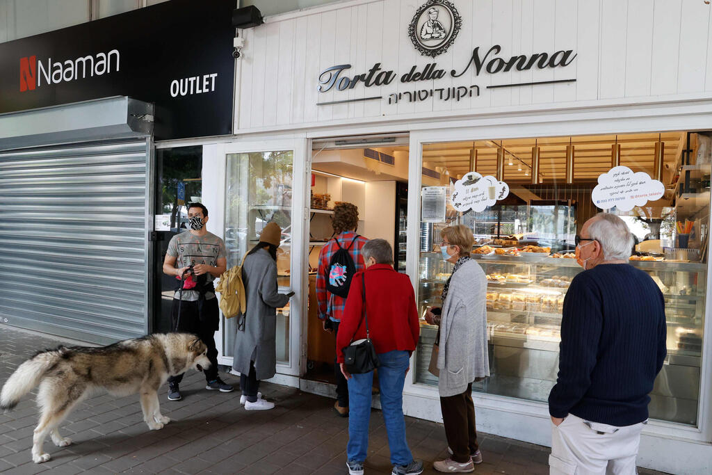 People queue in front of a bakery in Tel Aviv on Sunday following the lifting of a nationwide lockdown 