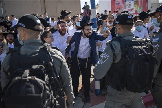 Police officers face off against Haredi protesters against coronavirus restrictions in the southern city of Ashdod 