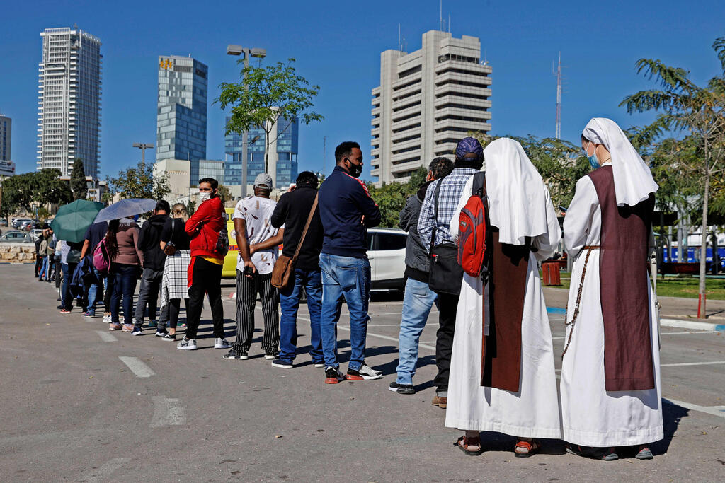 French nuns living in Israel queue with other foreign residents to receive the coronavirus vaccine in Tel Aviv 