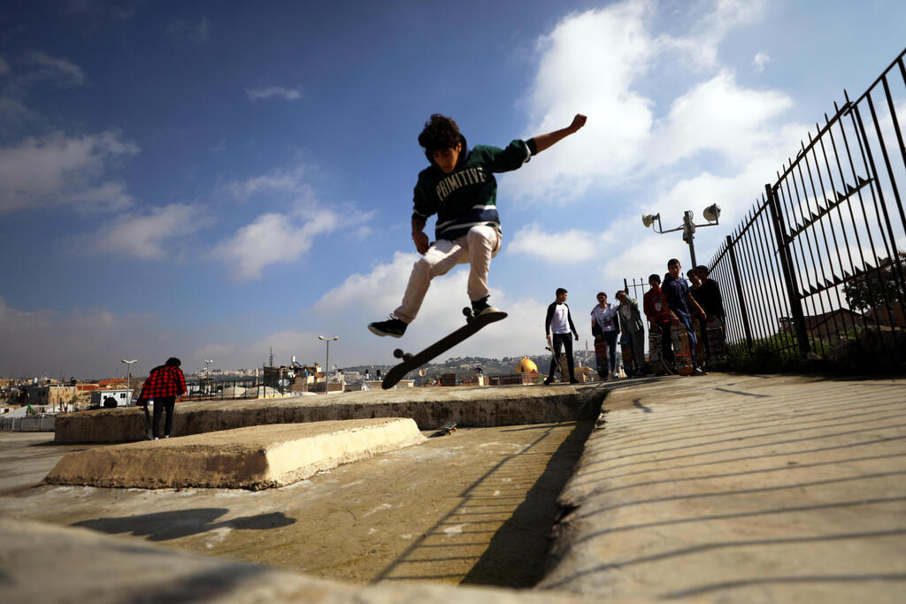 A Palestinian youth jumps with his skateboard on a rooftop as the Dome of the Rock located on the compound known to Muslims as Noble Sanctuary and to Jews as Temple Mount is seen in the background, as Israel partially lifts its third national lockdown to fight the coronavirus disease (COVID-19) crisis, in Jerusalem's Old City 
