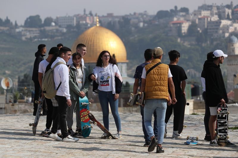 Palestinian youths hold their skateboards while standing on a rooftop, as Israel partially lifts its third national lockdown to fight the coronavirus disease (COVID-19) crisis, in Jerusalem's Old City 