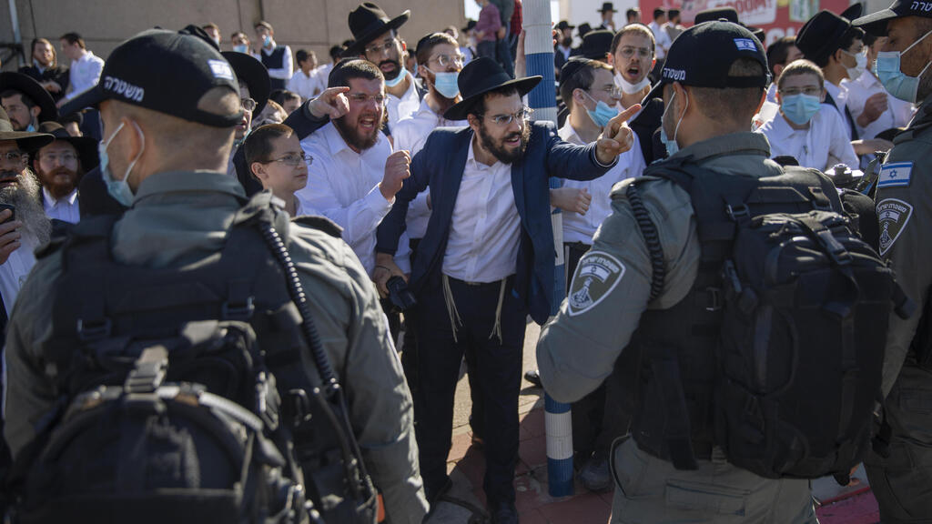 Ultra-Orthodox Jews argue with Israeli border police officers during a protest over the coronavirus lockdown restrictions, in Ashdod 